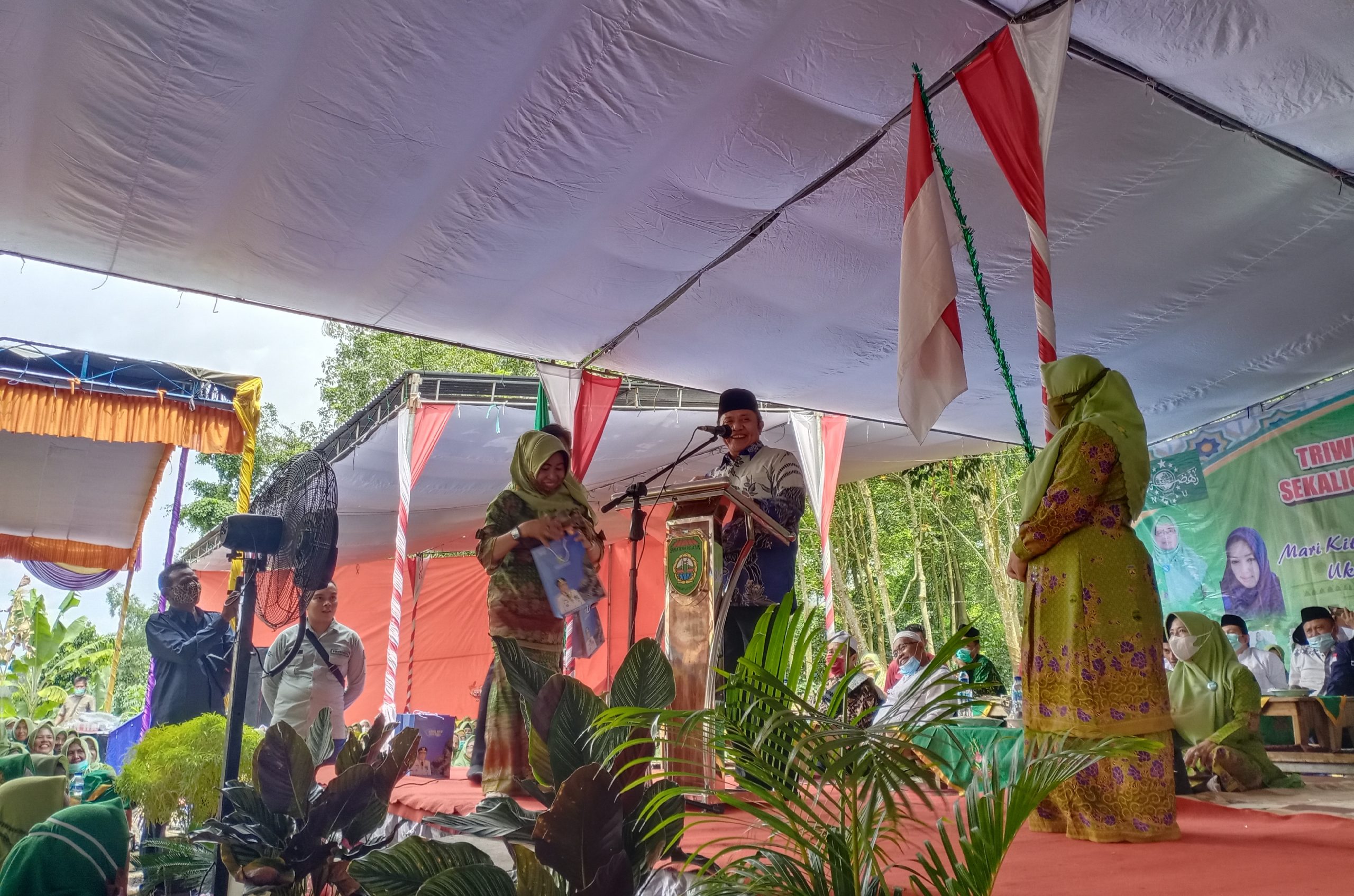 Gubernur Sumatera Selatan Herman Deru saat meberikan hadiah kepada salah satu anggota Muslimat NU PAC Buay Pemuka Peliung, di Desa Bantan Pelita, Kecamatan Buay Pemuka Peliung.