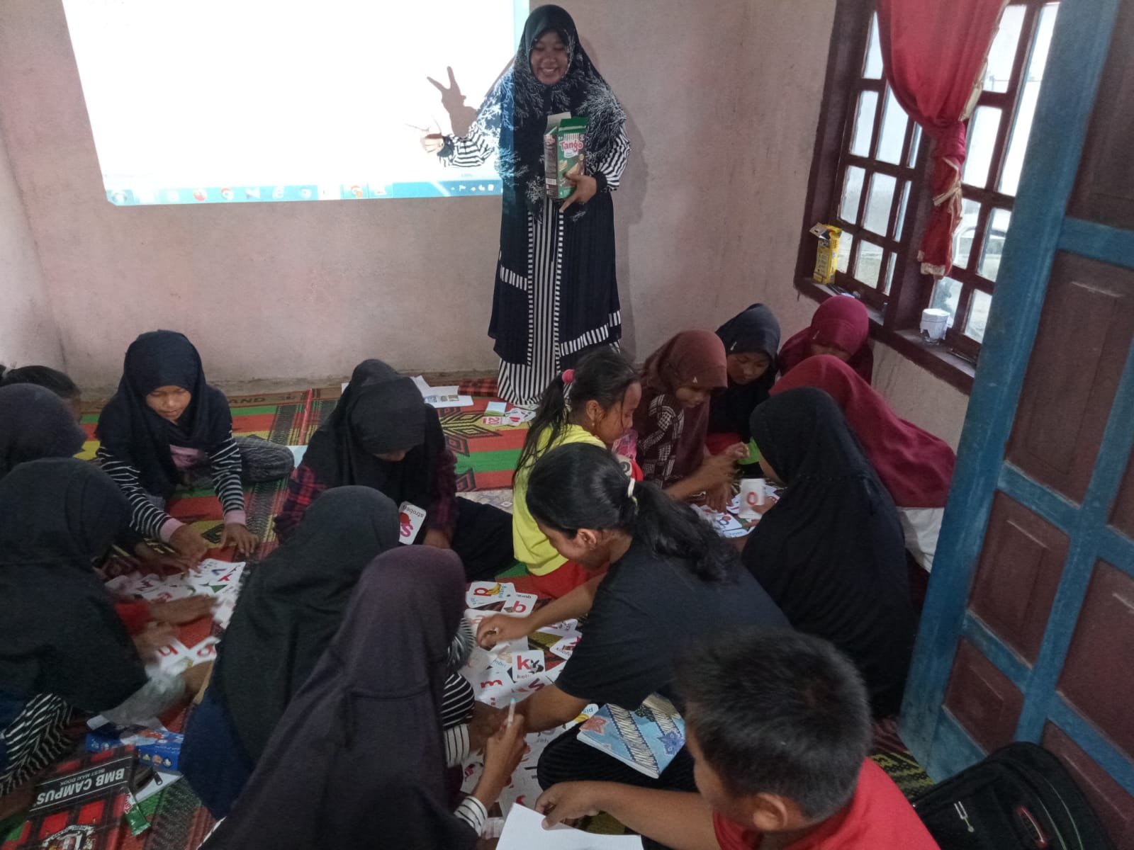 Tim Pengbdian Masyarakat Universits Nurul Huda sedang Melatih Kemahiran Menulis Bahasa Inggris Siswa SD dengan Scramble Game di Desa Karang Jaya, Kecamatan Belitang II.