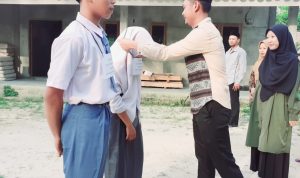 Tampak Dewan Guru SMK Cendikia OKU Timur melakukan Penyematan simbolis tanda peserta Masa Pengenalan Lingkungan Sekolah (MPLS) Saat upacara pembukaan MPLS SMK Cendikia OKU Timur. Di Halaman SMK Cendikia OKU Timur, Desa Sri Mulyo, Kecamatan Madang Suku II, Kabupaten OKU Timur. Belum lama ini.